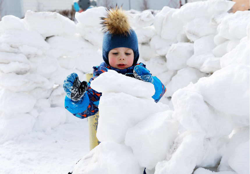 child builds snowfort