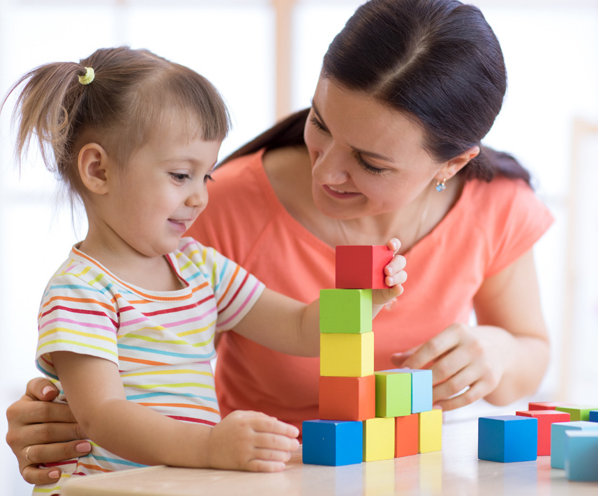 child and adult playing with building blocks