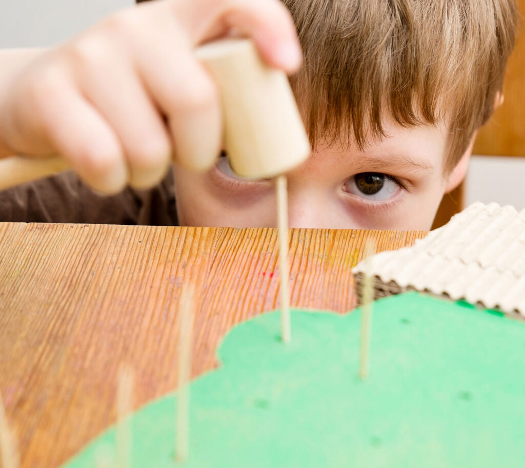 child builds wooden toys
